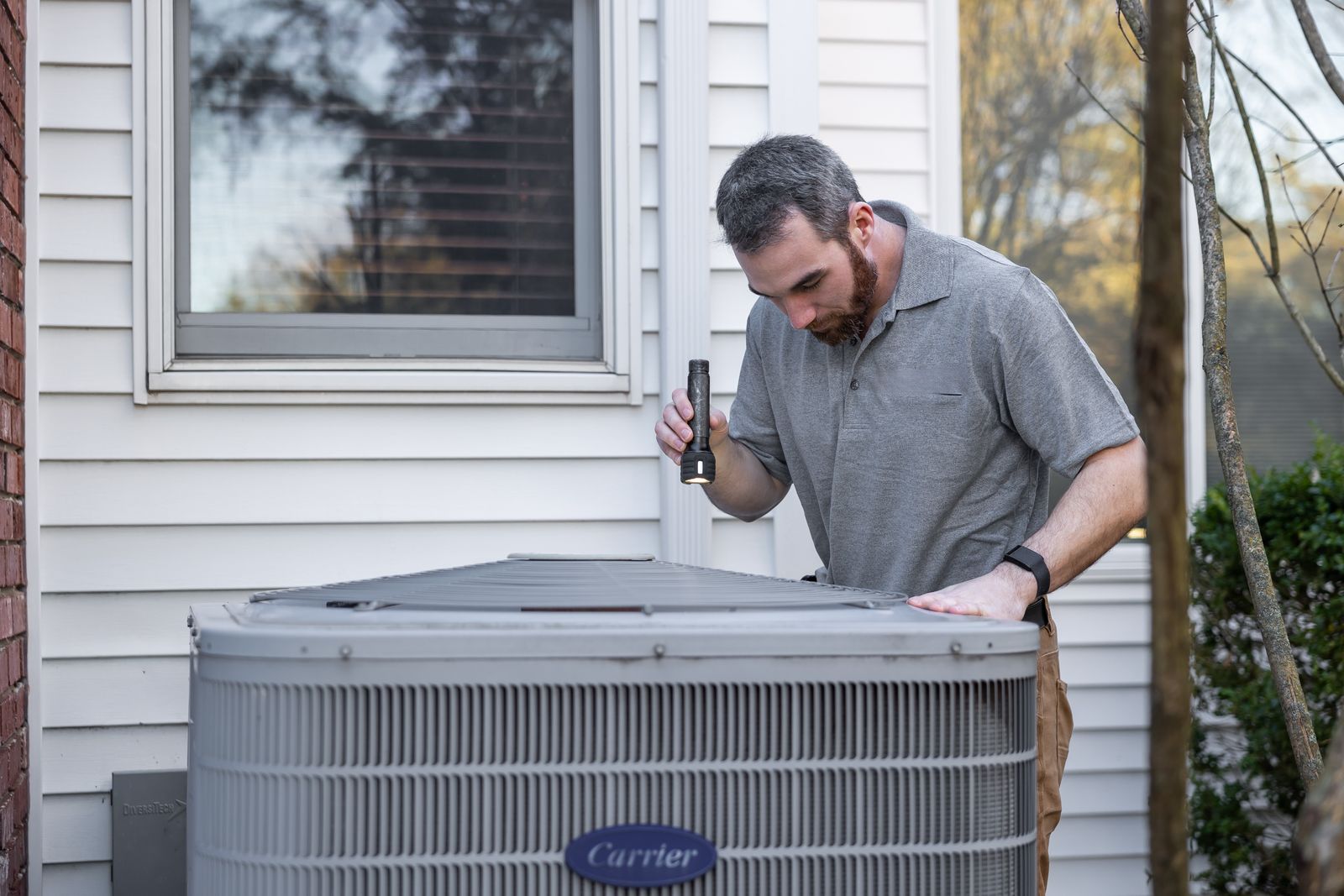 Technician servicing an outdoor air conditioner unit